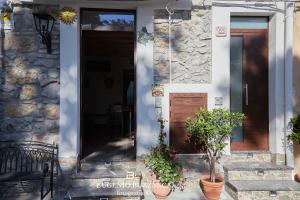 a stone house with a door and two potted plants at La Casa Dei Cavalieri in Caccamo