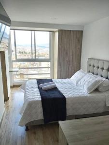 sypialnia z dużym łóżkiem i dużym oknem w obiekcie Luxury la Candelaria Bogota w mieście Bogota