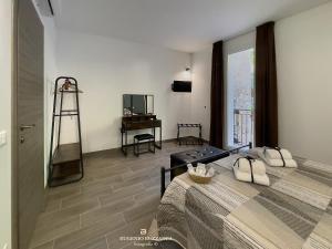 a bedroom with a large bed and a television and a room with at La Casa Dei Cavalieri in Caccamo