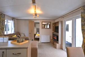 een keuken en een woonkamer met een bank en een tafel bij Rohannah static Caravan Fantastic Family and Friends Holiday in East Mersea