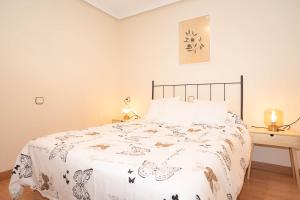 a bedroom with a bed with a white comforter at 10A02 Precioso apartamento Pravia in Pravia