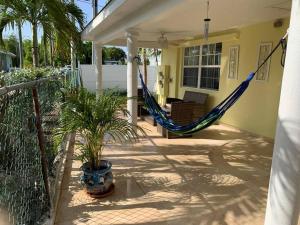 um alpendre com uma rede de descanso numa casa em The Diver's Inn Grand Cayman em George Town