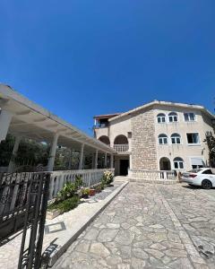 a building with a stone walkway next to a building at Guesthouse Vila Tamburic in Becici