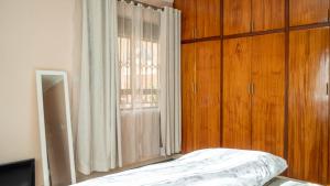 ein Schlafzimmer mit einem Bett und einem großen Fenster in der Unterkunft The Terrace Villa in Kampala