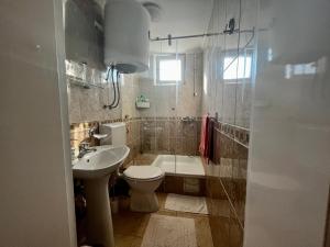 e bagno con servizi igienici, lavandino e vasca. di Apartman Simona a Vrdnik