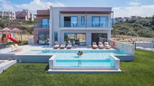 a person in a pool in front of a house at Star Luxury Villa - Private pool, gym, playground in Kato Daratso +56 photos