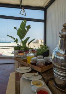 une table avec des assiettes de nourriture et une grande fenêtre dans l'établissement Olives at Santa Monica, à Marsa Matruh