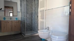 La salle de bains est pourvue de toilettes et d'une douche en verre. dans l'établissement La Quinta Decima Bioagriturismo, à Fattoria Spedaletto