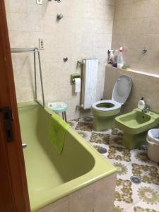 La salle de bains est pourvue d'une baignoire verte et de toilettes. dans l'établissement Renata, à Formia