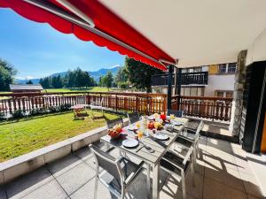 patio con mesa y sillas en el balcón en Fontainebleau Golf in Golf out, en Crans-Montana