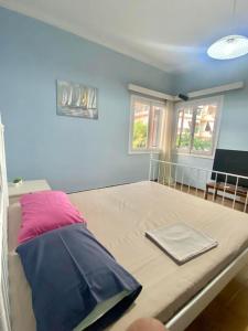 Ce lit se trouve dans un dortoir doté d'un oreiller violet. dans l'établissement Tiffany's 5' min from airport, à Spáta