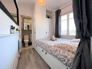 a small bedroom with a bed and a window at Le Cyrano, Deauville - App. T2 proche de la mer in Deauville