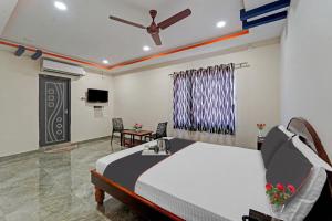 a bedroom with a bed and a tv in a room at Capital O Hotel Lakshmi Residency in Tirupati