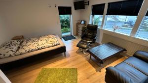 1 dormitorio con 1 cama, 1 sofá y 1 silla en Ingi's Guesthouse with a Car, en Miðvágur
