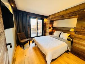1 dormitorio con 1 cama, 1 silla y 1 ventana en Fontainebleau Golf in Golf out, en Crans-Montana