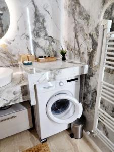 een witte wasmachine in een badkamer met een wastafel bij Acropolis Memories greendom in Athene