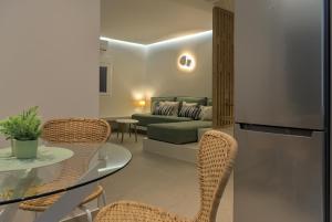 a living room with a couch and a table and chairs at Les Maisonettes in Kokkari
