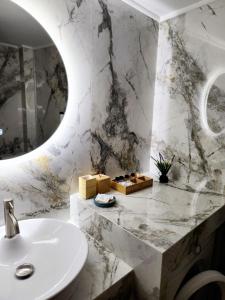 een witte badkamer met een wastafel en een spiegel bij Acropolis Memories greendom in Athene
