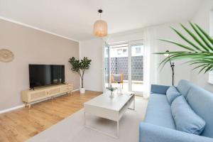 a living room with a blue couch and a tv at Moderne & Elegante Terrassenwohnung - Wifi - TV in Bielefeld