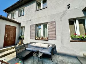 a patio with a couch and a table in front of a building at Pokoje gościnne u Piotra in Międzyzdroje