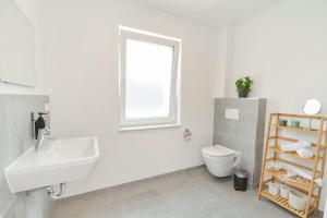 a white bathroom with a sink and a toilet at Moderne & Elegante Terrassenwohnung - Wifi - TV in Bielefeld