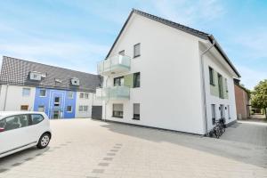 un coche blanco estacionado frente a un edificio en Moderne & Elegante Terrassenwohnung - Wifi - TV, en Bielefeld