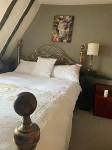a bedroom with a large bed with white pillows at Quirky 18th Century Thatched Cottage in Great Staughton