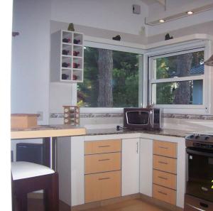 cocina con encimera, microondas y ventana en Casa en Pinamar Alquiler en Pinamar