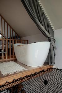 a large white bath tub sitting in a room at Domki Pod Lasem - Domek Brzozowy in Stronie Śląskie