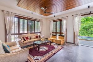 a living room with a couch and a table at SaffronStays Amrapali - 5BHK Villa in Nashik with Pool, Lawn & Kids Play Area in Deolāli +32 photos