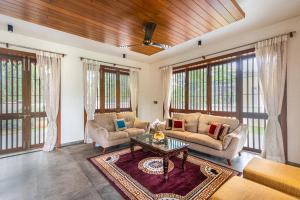a living room with two couches and a table at SaffronStays Amrapali - 5BHK Villa in Nashik with Pool, Lawn & Kids Play Area in Deolāli