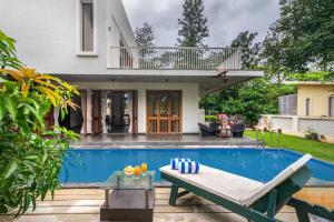 a villa with a swimming pool and a house at SaffronStays Amrapali - 5BD Farmstay with private pool in Nashik in Deolāli