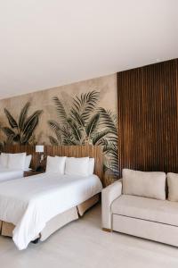 Habitación de hotel con 2 camas y sofá en Soleare Hotel Boutique en Tampico
