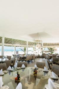 uma sala de jantar com mesas e cadeiras e o oceano em Soleare Hotel Boutique em Tampico