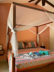 um quarto com uma cama de dossel em Surfside Mar Y Posa em Playa Flamingo