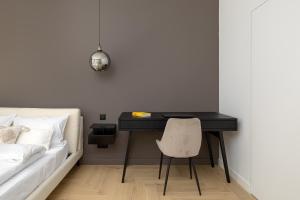 Schlafzimmer mit einem Schreibtisch, einem Bett und einem Stuhl in der Unterkunft ECRU 3-Bedroom Luxurious Apartment with City View WWA22 in Warschau