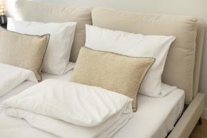 una pila de almohadas blancas en un sofá en ECRU 3-Bedroom Luxurious Apartment with City View WWA22, en Varsovia