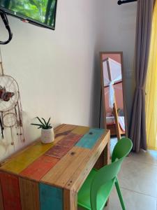 Habitación con mesa de madera y sillas verdes. en Surfside Mar Y Posa en Playa Flamingo