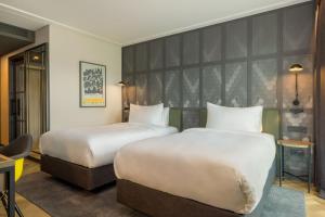 a hotel room with two beds and a large headboard at Four Points by Sheraton Budapest Danube in Budapest