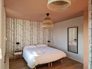 ein Schlafzimmer mit einem weißen Bett und zwei Lampen in der Unterkunft Le Nid du Chardonnay 