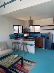 a living room with a kitchen with blue tiles at Chakana Lofts in El Pescadero