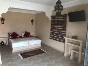 a bedroom with a bed and a tv on the wall at Dar Tiziri Amizmiz in Marrakech