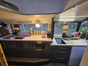 a kitchen in an rv with a sink and a stove at Mooview- the charming double decker bus in Norton
