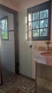 a bathroom with a sink and a window and a door at Villa dos Pássaros Paraty Hospedagem in Paraty +123 photos