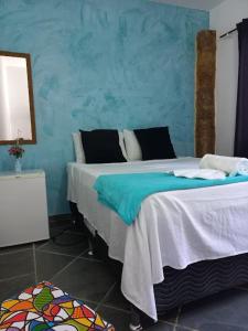 a bedroom with two beds and a blue wall at Villa dos Pássaros Paraty Hospedagem in Paraty