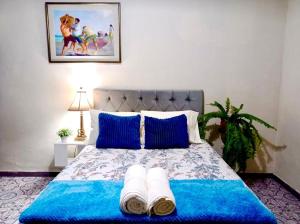 een slaapkamer met een blauw bed en handdoeken bij Private Guest House in Lima