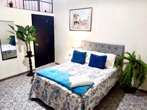 a bedroom with a large bed with blue pillows at Private Guest House in Lima