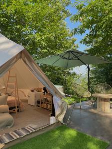 a tent with a table and an umbrella at Il Bosco di Paolo - Glamping in Sestola