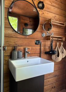 ein Badezimmer mit einem weißen Waschbecken und einem Spiegel in der Unterkunft Il Bosco di Paolo - Glamping in Sestola