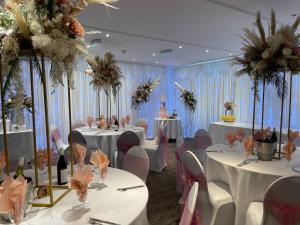un salón de banquetes con mesas, sillas y flores en The Gardeners Country Inn, en Goxhill
